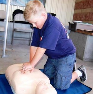 Six-year-old Conner Alexander practices hands-only CPR.