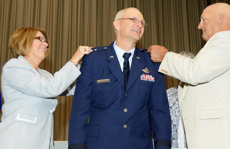 Arnold "Arnie" Bunch Jr., Air Force Test Center commander, has his wife Caroline and his father Arnie Sr. pin on his major general rank of two stars during his promotion ceremony Aug. 23. Bunch was formally promoted to major general after being frocked to the rank in April. The ceremony was attended by family and friends along with Airmen, civilians and contractors of Team Edwards. (U.S. Air Force photo by Rebecca Amber) 