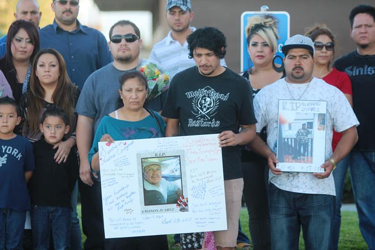 Surrounded by family members and loved ones, wife Maria and son Victor, hold a poster of Luciano Meza Juarez at a candlelight vigil in his memory on Tuesday, Oct. 1, 2013. (Photo by TONY CHEVAL)