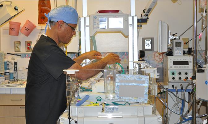 Dr. Thangavel checks on one of his tiny patients in the NICU. (Courtesy AVH)