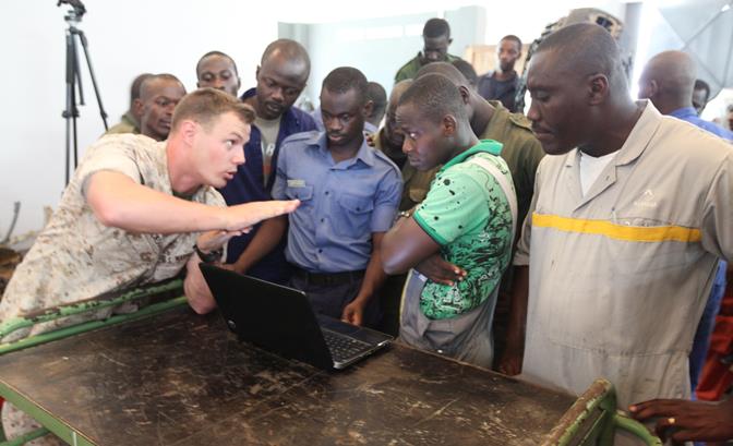 Jackson describes the gear case of a small-boat engine to a group of Ghanaian sailors in Takoradi, Ghana, March 17. (Photo by 1st Lt. James Stenger)
