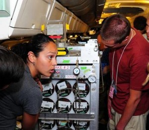 Josette Marrero, a Ph.D. candidate in the Rowland-Blake Lab at UC Irvine, explains the installation of the Whole Air Sampler on board NASA's DC-8 to Student Airborne Research Program participants. (JANE PETERSON)