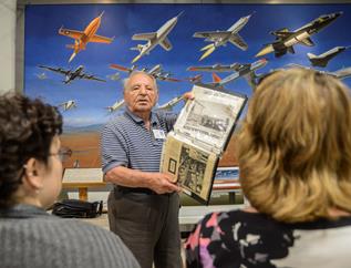 Albert Rosa shares newspaper clippings that show the living quarters inside of a concentration camp during World War II. (Rebecca Amber)