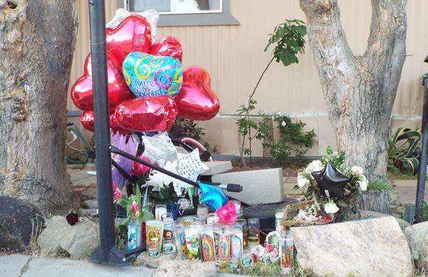 Balloons and candles mark the spot where a teenager shot Friday at the Friendly Village mobile home park. Friends and family members who held a candlelight vigil at the scene Saturday evening identified the victim as Rosie Cruz.(Photo by LUIS MEZA)
